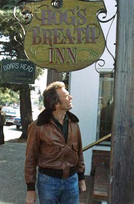 Cling Eastwood standing below the sign hanging from his restaurant in Carmel, California
